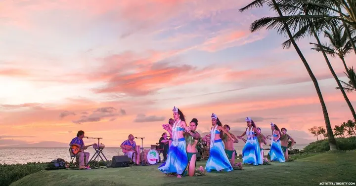 Hula dancers performing beneath a pink sunset sky at the Feast at Mokapu luau