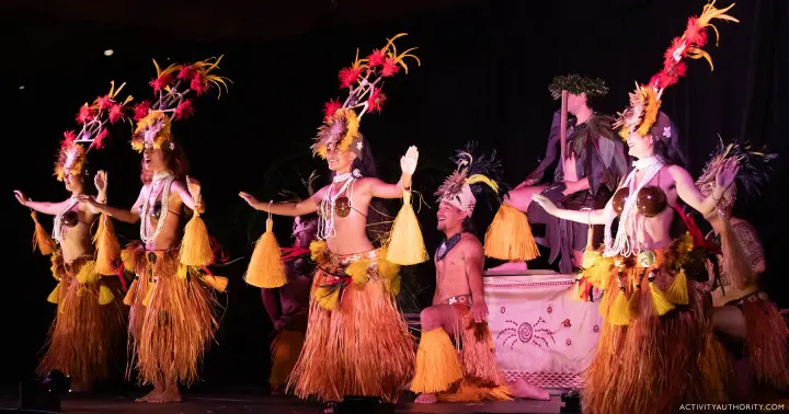 Performers in red and gold costumes on stage at the Kapa Moe Luau in Kapalua