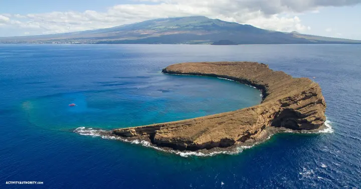 Aerial view of the crescent-shaped Molokini Crater and its clear blue snorkeling waters off South Maui