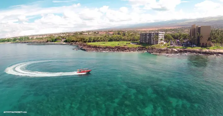 Redline Rafting boat carving a wake through turquoise water along the South Maui coast